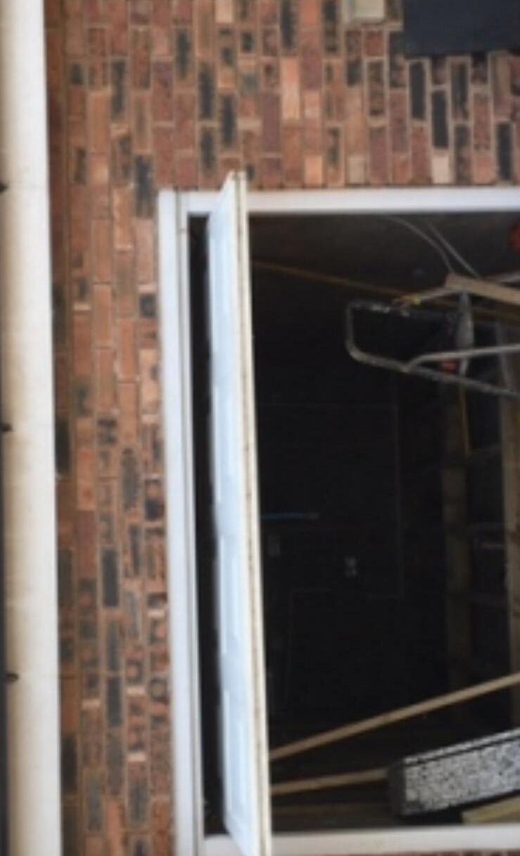 New white door frame being installed within a brick opening