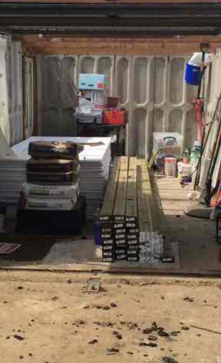 Garage interior stripped out with materials stored ready for conversion