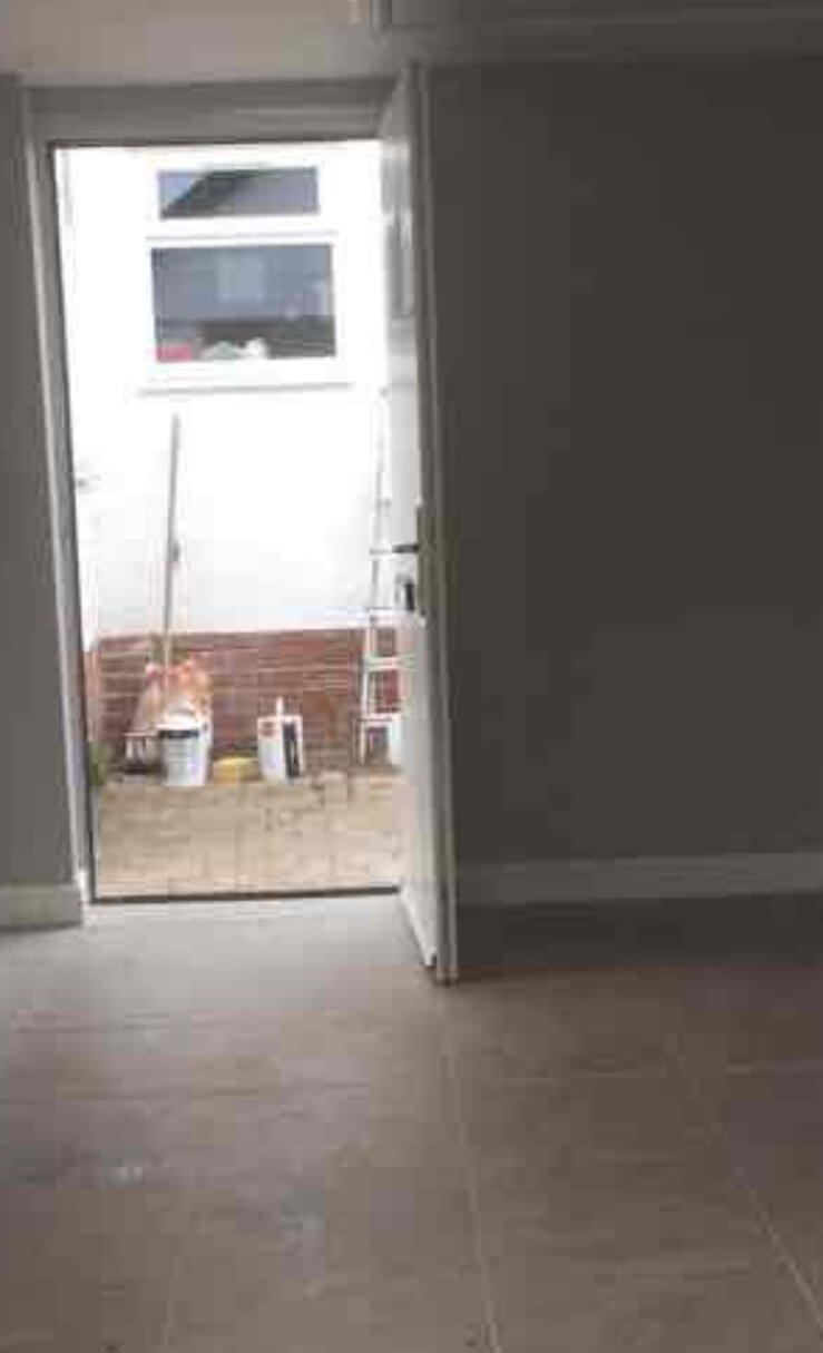 Interior doorway with tiled floor leading through to a bright hallway