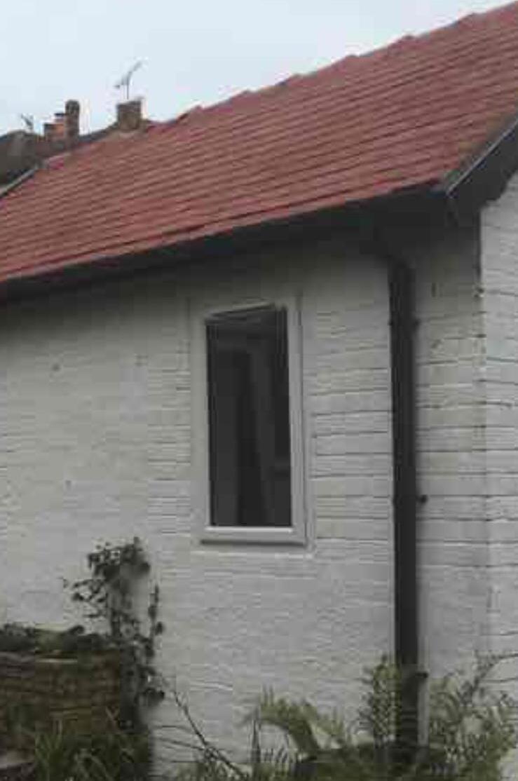 Rendered bungalow with red tiled roof and a new window fitted