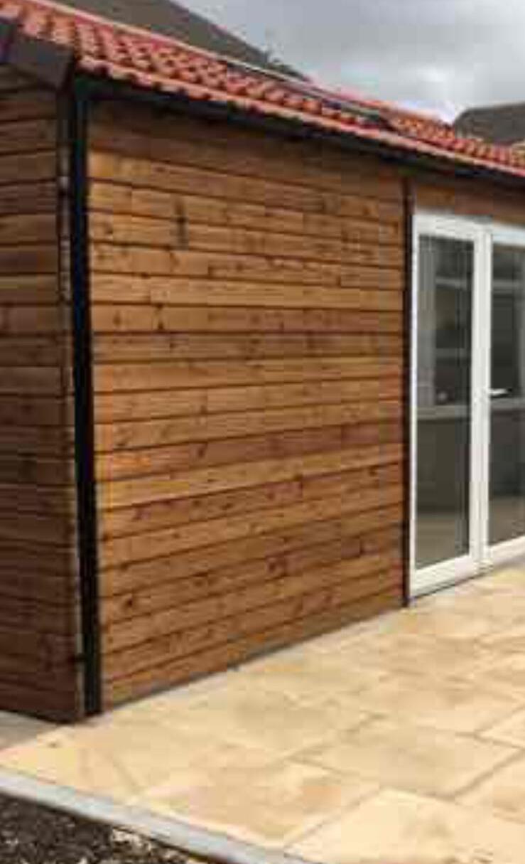 Finished timber clad garden room alongside a new sandstone patio