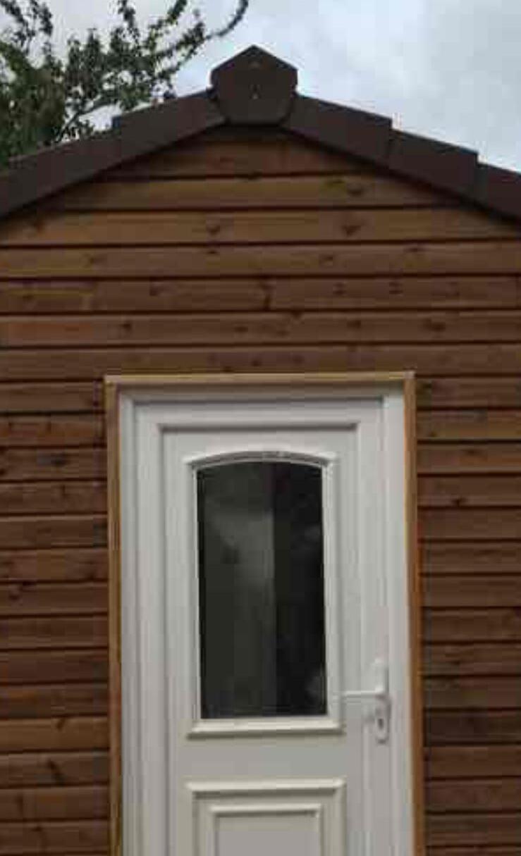 Timber clad garden room with a white uPVC door
