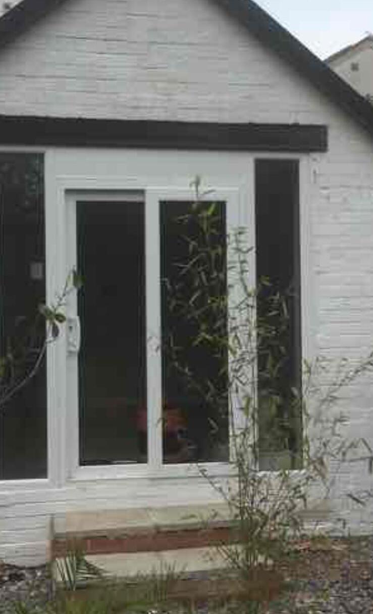White rendered building with new patio doors opening onto the garden